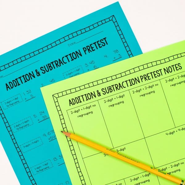 Addition & subtraction pretest worksheets on brightly-colored paper with a pencil laying on top